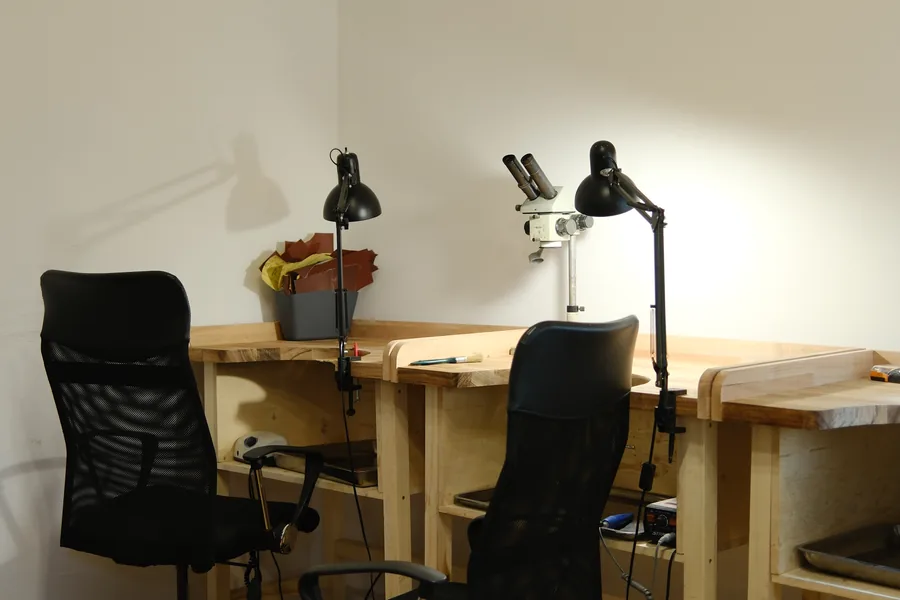 A row of benches with lamps and plants under the studio windows