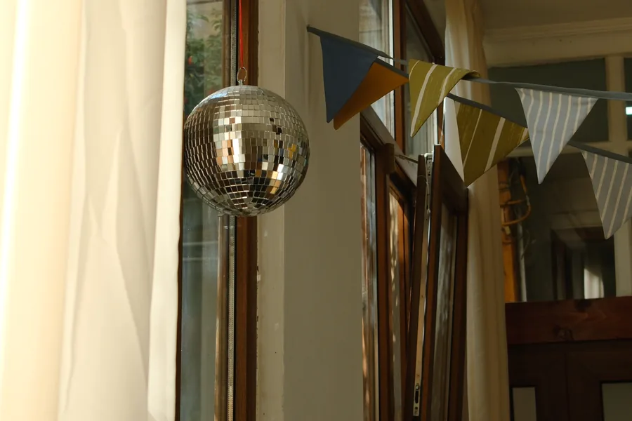 A disco ball and a string of bunting by the studio window