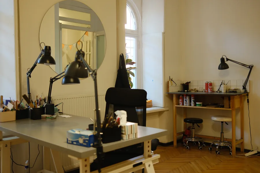 The studio: benches with lamps, a round mirror and arched windows