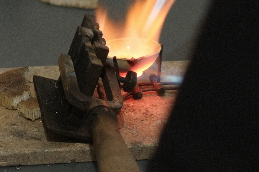 A torch flame over the crucible: silver melting before casting