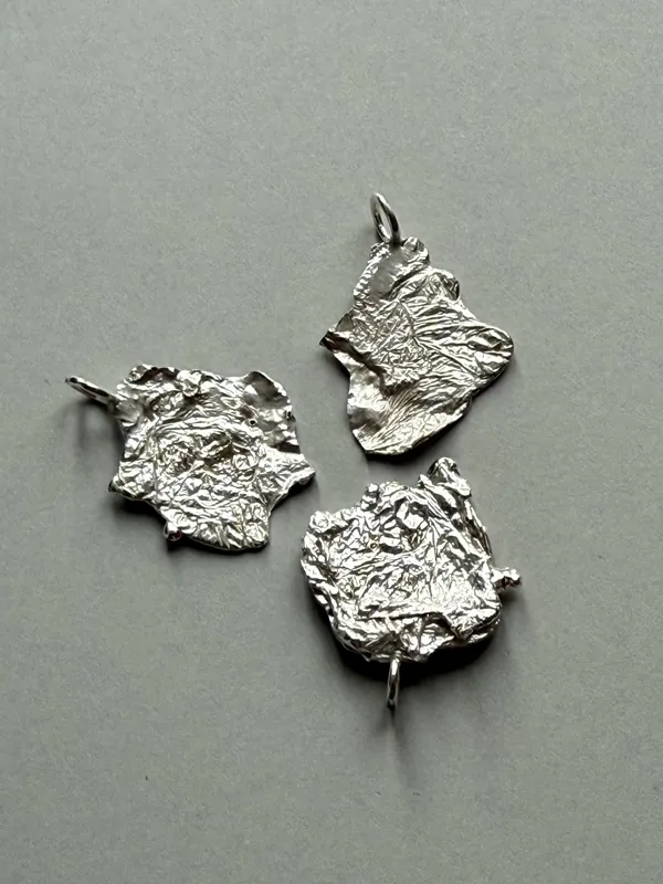 Cast silver pendants with irregular edges